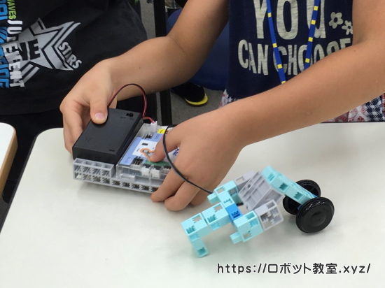 ブロックを組み立ててロボットを作る小学1年生
